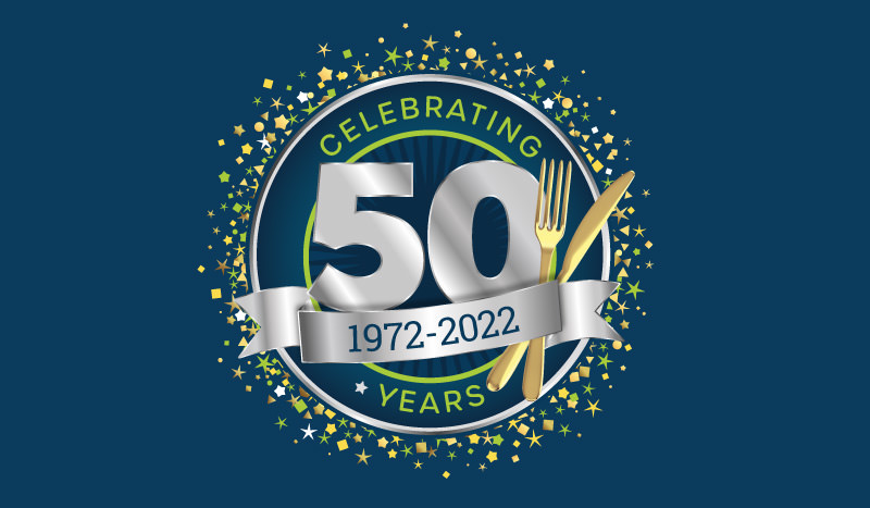 50th Anniversary Celebration Event logo with green, gold and tan confetti stars on the outside, a navy circle with a darker navy burst in the middle and a metallic silver ribbon and metallic gold knife and fork, on a navy background