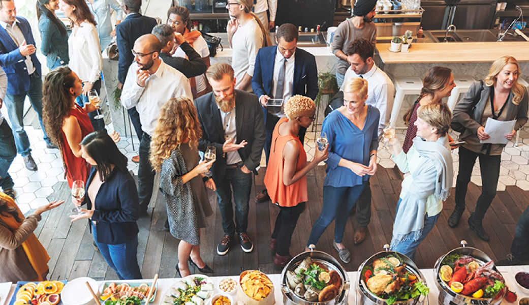 Group of people mingling at a business gathering with food