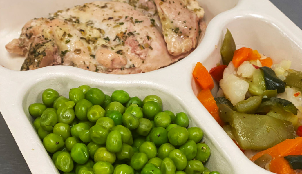 Daily meal deliveries features tray with chicken, peas, and mixed vegetables