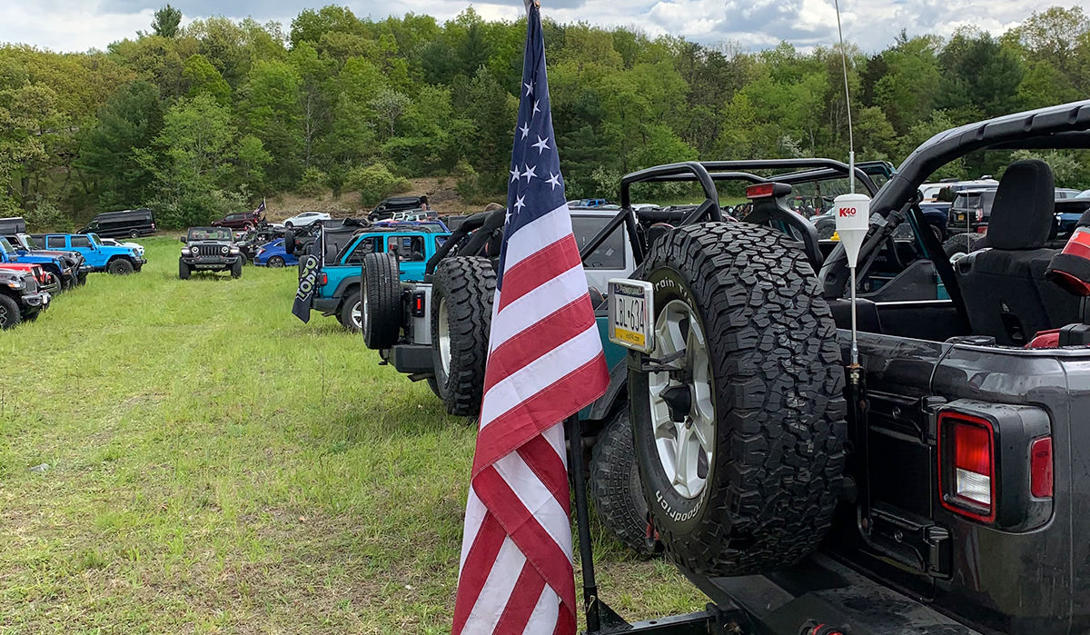 Jeep go topless day event showcasing jeeps in a grass field with an American flag