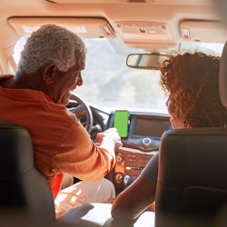 Man and woman talking and riding in a car with smartphone