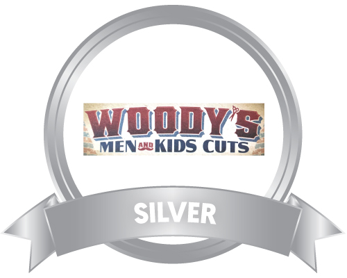 Woody’s Men and Kids Cuts logo in a metallic light gray circle with a metallic light gray Silver Sponsor ribbon at the bottom